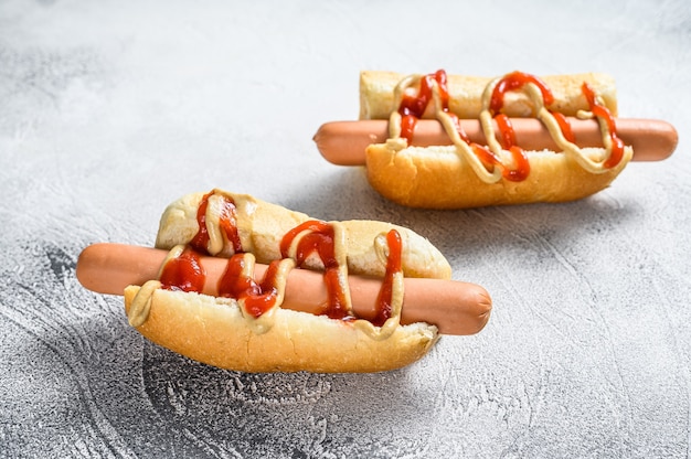 Hot Dog mit gelbem Senf und rotem Ketchup. Weißer Hintergrund. Draufsicht.