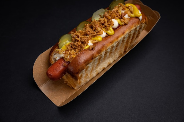 Hot Dogs in Papptellern mit Würstchen und Soße