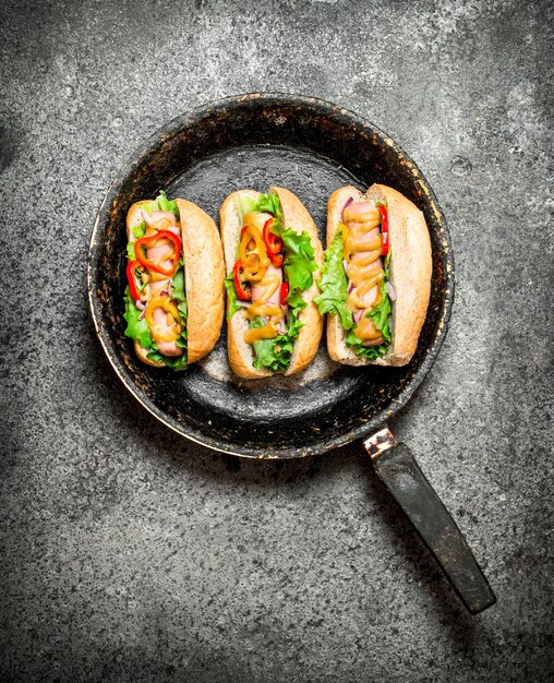 Hot Dogs mit Kräutern und Gemüse in der Pfanne