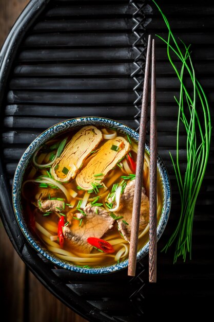 Hot Red Curry-Suppe mit Rindfleisch auf dunklem Tisch