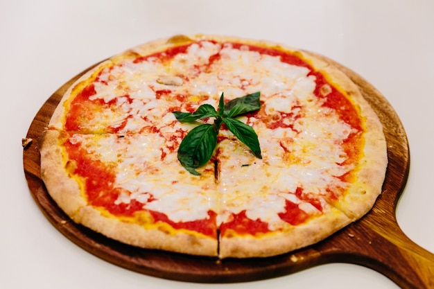 Hot servido Pizza Margherita en placa de madera con aceite de oliva.