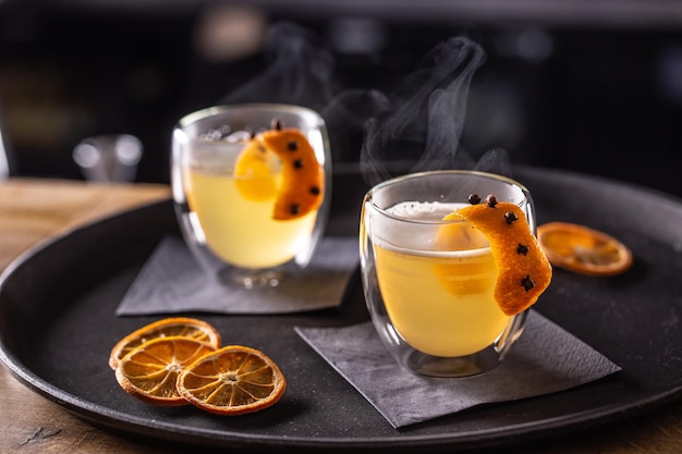 HOT TODDY-Getränk aus Whiskey, einfachem Sirup, heißem Wasser, Nelken und Orangenschale, das für Kunden im Pub auf der Bartheke bereitsteht