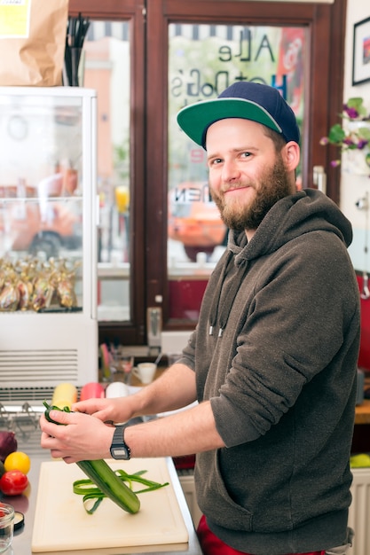 Hotdog: amable chef que prepara ingredientes frescos en un bar de comida rápida.