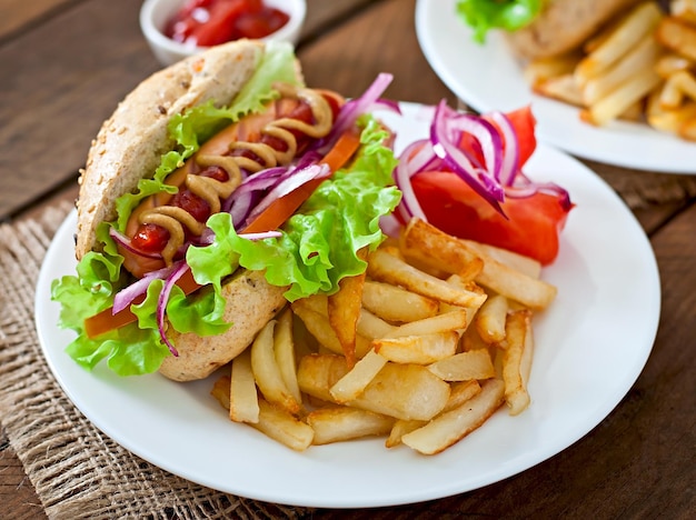 Hotdog mit Ketchup, Senf und Salat auf Holzgrund