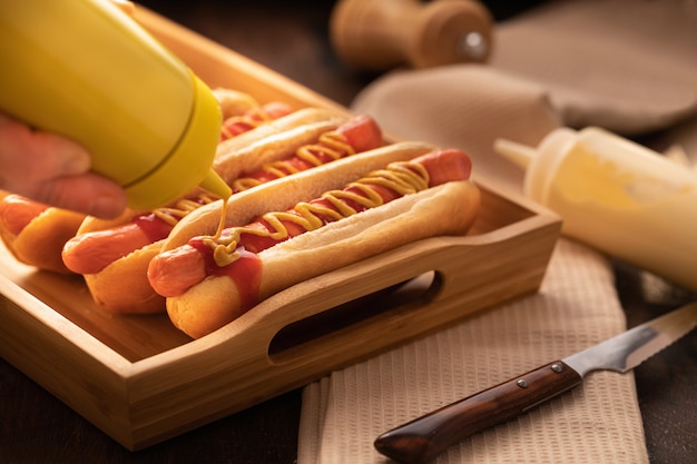 Hotdog mit Pfeffer, Tomate, Kopfsalat und Salat mischen auf hölzernem.
