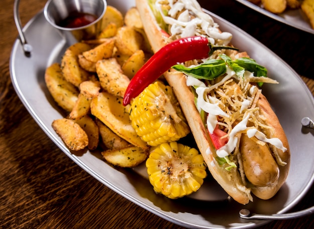 Hotdogs e batatas fritas em uma louça. Refeição de fast-food. Restaurante.