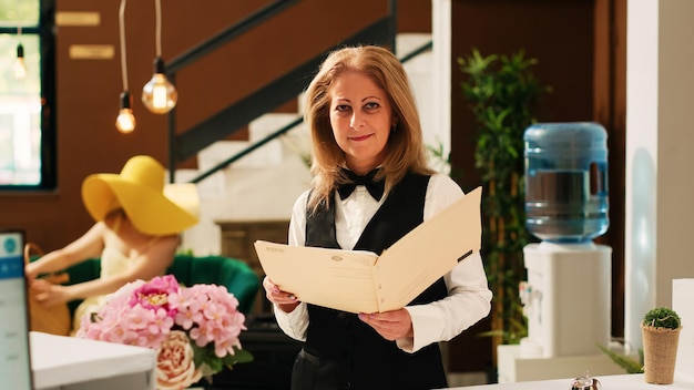 Hotel-Concierge, der Buchungen oder Reservierungen überprüft, an der Rezeption in der Lobby arbeitet, um Reisenden beim Check-in zu helfen.