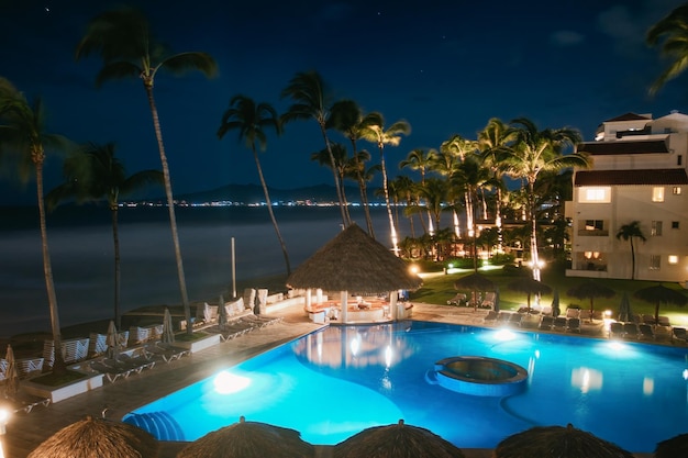 Hotel Marival bei Nacht mit Swimmingpool, Seewolkenbar und Palmen