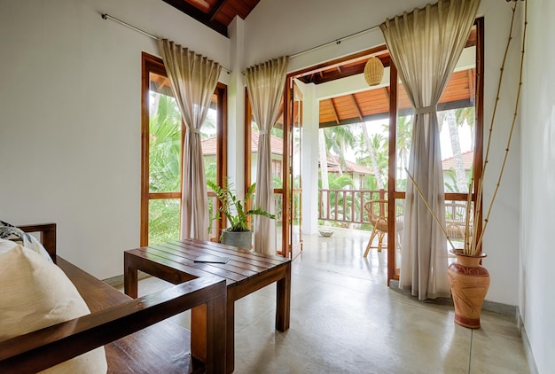 Hotel o casa residencial en habitación de jardín tropical con muebles de ventanas de terraza y vista de palmeras