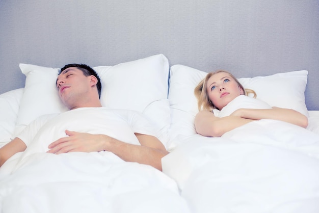 Hotel, Reisen, Beziehungen und Schlafprobleme Konzept - Familienpaar im Bett, Frau mit Schlaflosigkeit