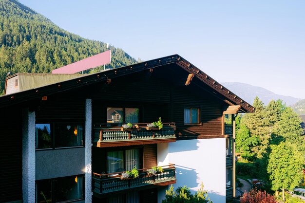 Hotel resort familiar e paisagem com natureza no verão na Áustria. Projeto moderno de casa de madeira entre montanhas. Fachada exterior do complexo de edifícios. Villa vista frontal. Relaxe nas férias.