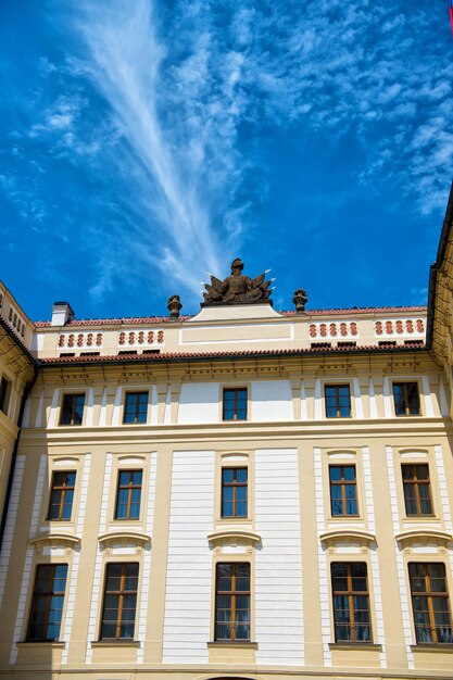 Housse con paredes de fachada beige y ventanas en un día soleado sobre fondo de cielo azul.