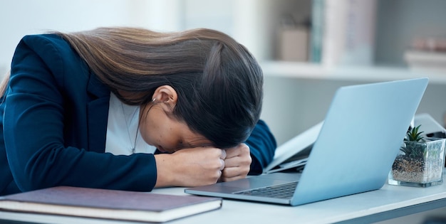 Hoy no puedo hacer nada bien Foto de una joven empresaria durmiendo en su escritorio en una oficina