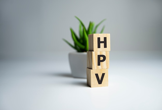 HPV-Wort geschrieben mit Holzblock neben Pflanze