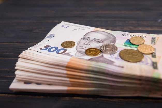 Hryvnia Ucrania, nuevos billetes de 500 hryvnia con monedas sobre un fondo de madera