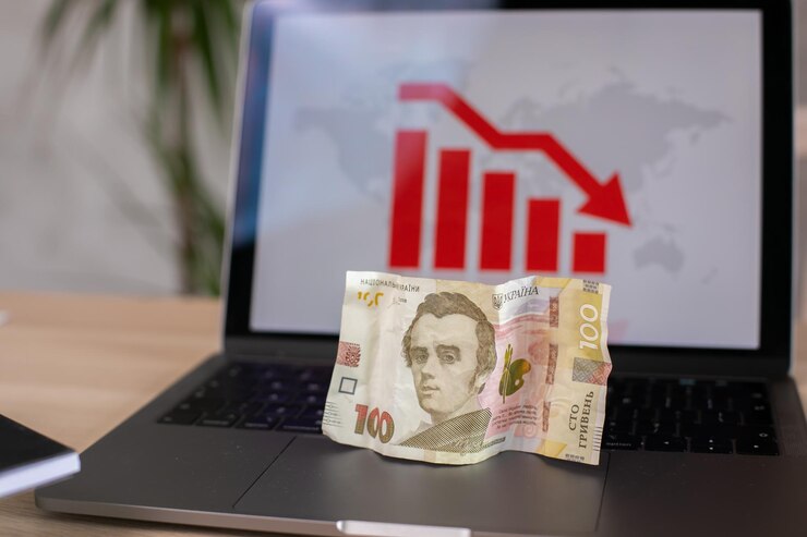 hryvnia ucraniana en el gráfico de caída en el fondo de la computadora portátil
