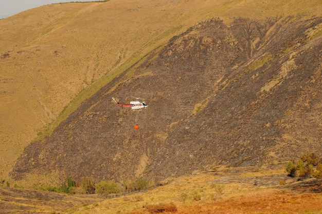 Hubschrauber gegen Brände, die eine Wasserableitung durchführen