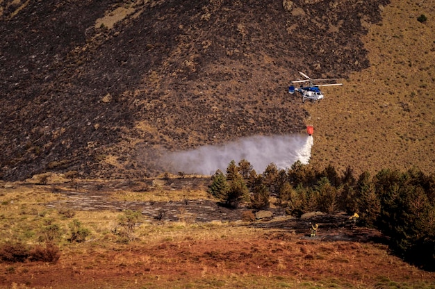 Hubschrauber gegen Brände, die eine Wasserableitung durchführen