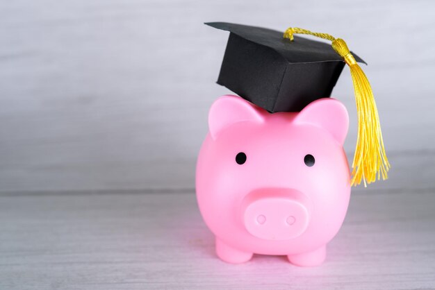 Hucha con gorra de graduación, concepto de beca de ahorro de educación financiera empresarial.