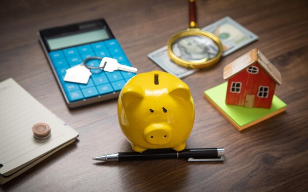 Foto hucha modelo de casa y dinero en la mesa de madera