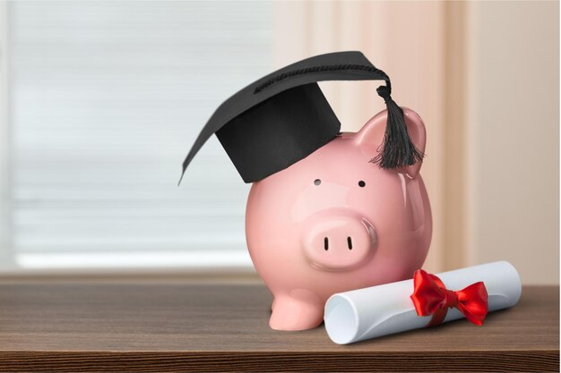 Hucha con sombrero de graduación, concepto de ahorro para la educación