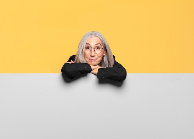 Hübsche ältere Geschäftsfrau mit grauem Haar und grauem Banner