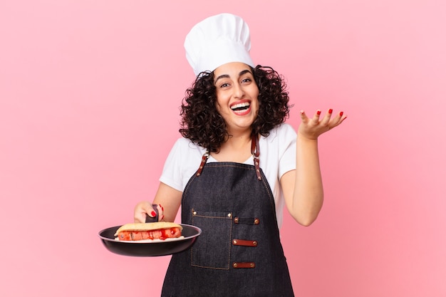 Hübsche arabische Frau Grillkoch, die Hot Dogs zubereitet
