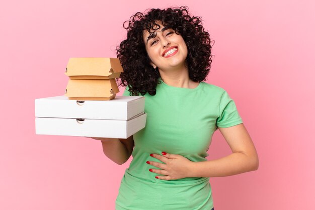 Hübsche arabische Frau mit Fast-Food-Boxen zum Mitnehmen