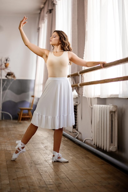 Hübsche Ballerina der jungen Frau, die im Tanzsaal übt