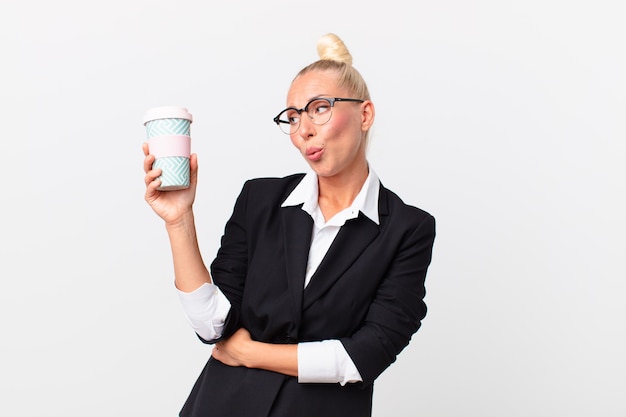 hübsche blonde erwachsene Geschäftsfrau mit einem Kaffee zum Mitnehmen