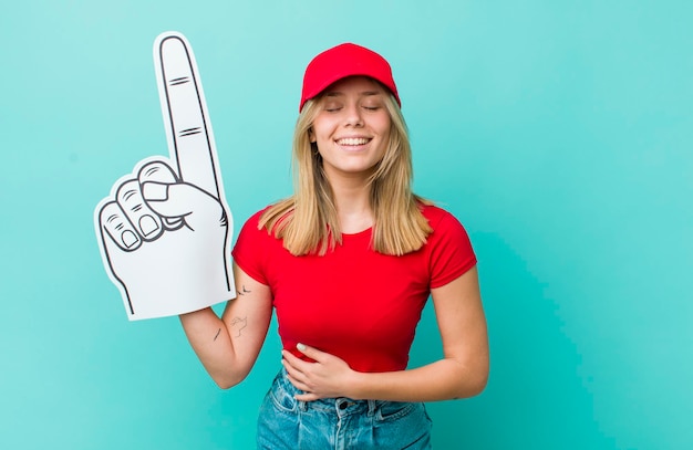 Foto hübsche blonde frau, die laut über ein urkomisches witz-nummer-eins-fan-konzept lacht