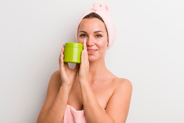 Hübsche blonde Frau mit einer Haarproduktflasche