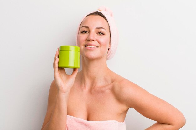 Hübsche blonde Frau mit einer Haarproduktflasche