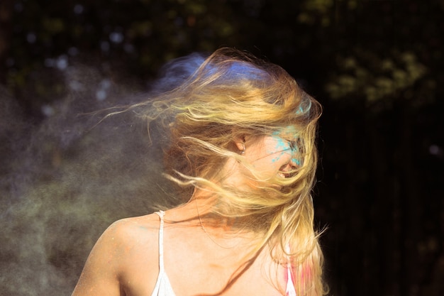 Foto hübsche blonde frau mit wind im haar posiert beim holi-festival