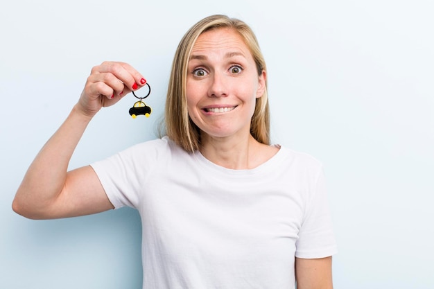 Foto hübsche blonde junge erwachsene frau mit einem autoschlüssel