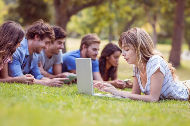 Hübsche Blondine, die Laptop im Park verwendet