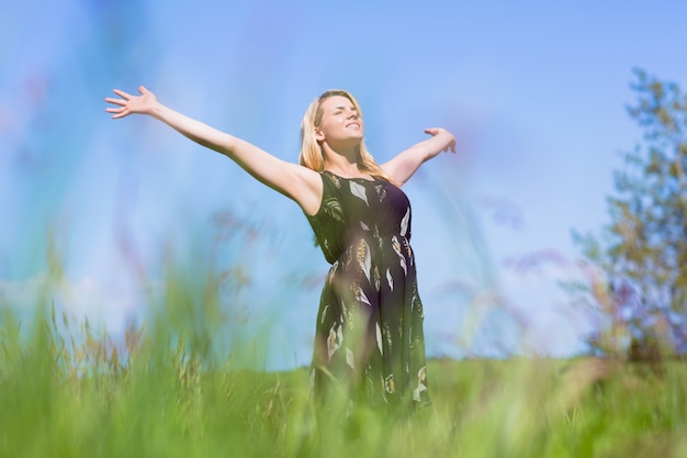 Hübsche Blondine in den sundress, die mit den Armen heraus stehen