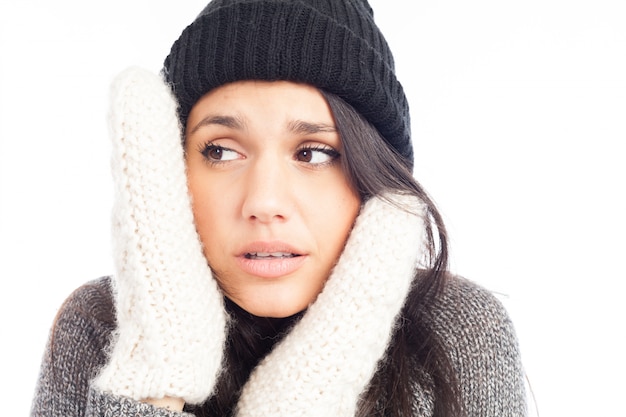 Hübsche Brunettefrau mit einem woolen Hut eine Strickjacke und Handschuhe, die Kälte hat