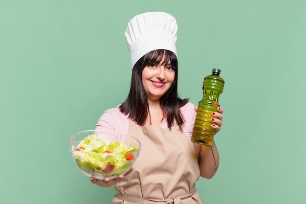 hübsche cheffrau glücklicher ausdruck und hält einen salat