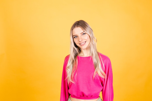 Hübsche europäische Frau in der rosa Bluse auf gelber Wand