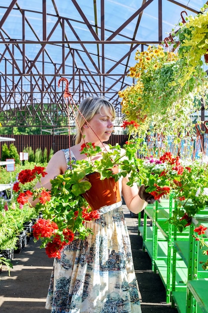 Hübsche Floristin arbeitet mit Blumen in einem Gartencenter.