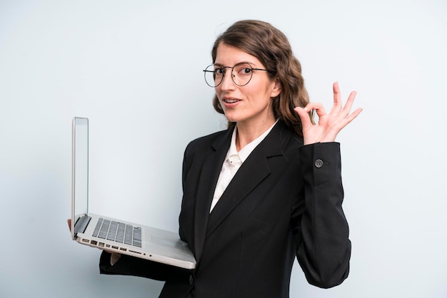 Hübsche Frau des jungen Erwachsenen, die einen Laptop hält