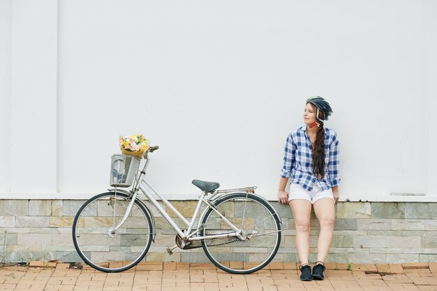 Hübsche Frau, die draußen nach dem Radfahren ruht