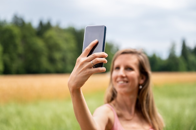 Hübsche Frau, die draußen Selfies macht