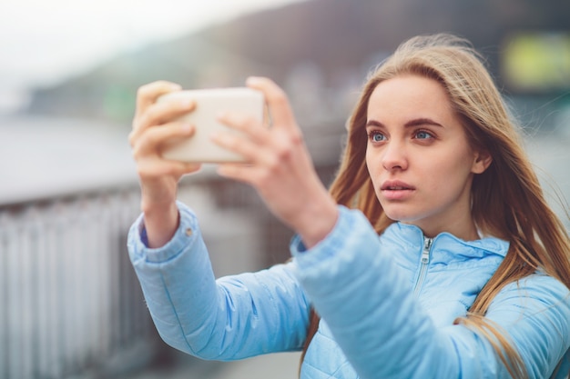 Hübsche Frau, die ein Selfie macht. Schönes Mädchen, das auf den Straßen geht und einige Wahrzeichen fotografiert. Blonde machte Fotos von sich