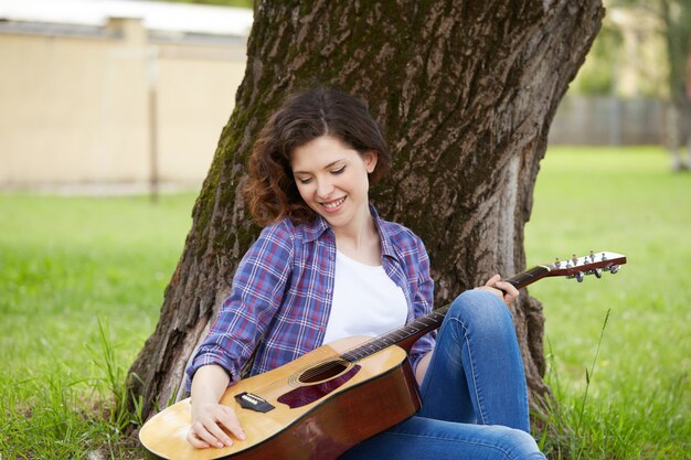 Hübsche Frau, die Gitarre spielt