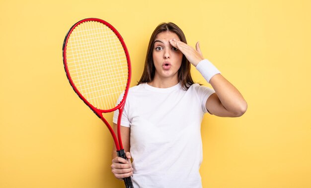 Hübsche Frau, die glücklich, erstaunt und überrascht aussieht. Tennisspieler-Konzept