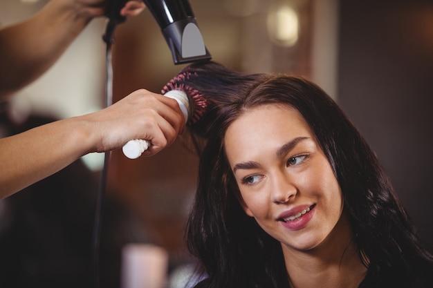 Hübsche Frau, die ihre Haare trocknen lässt