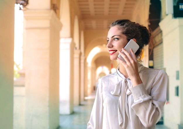 Hübsche Frau, die n das Telefon spricht