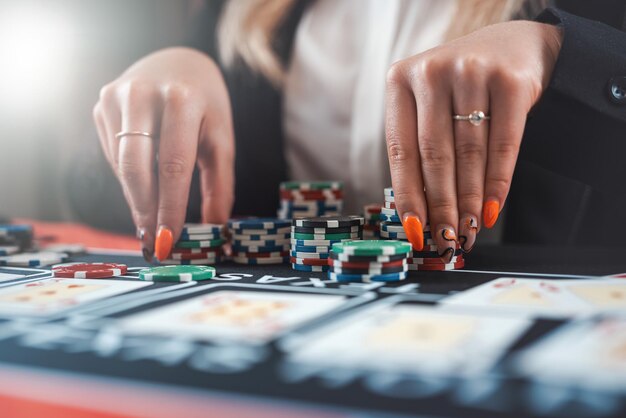 Hübsche Frau, die Poker spielt, macht einen Einsatz mit Chips All-in